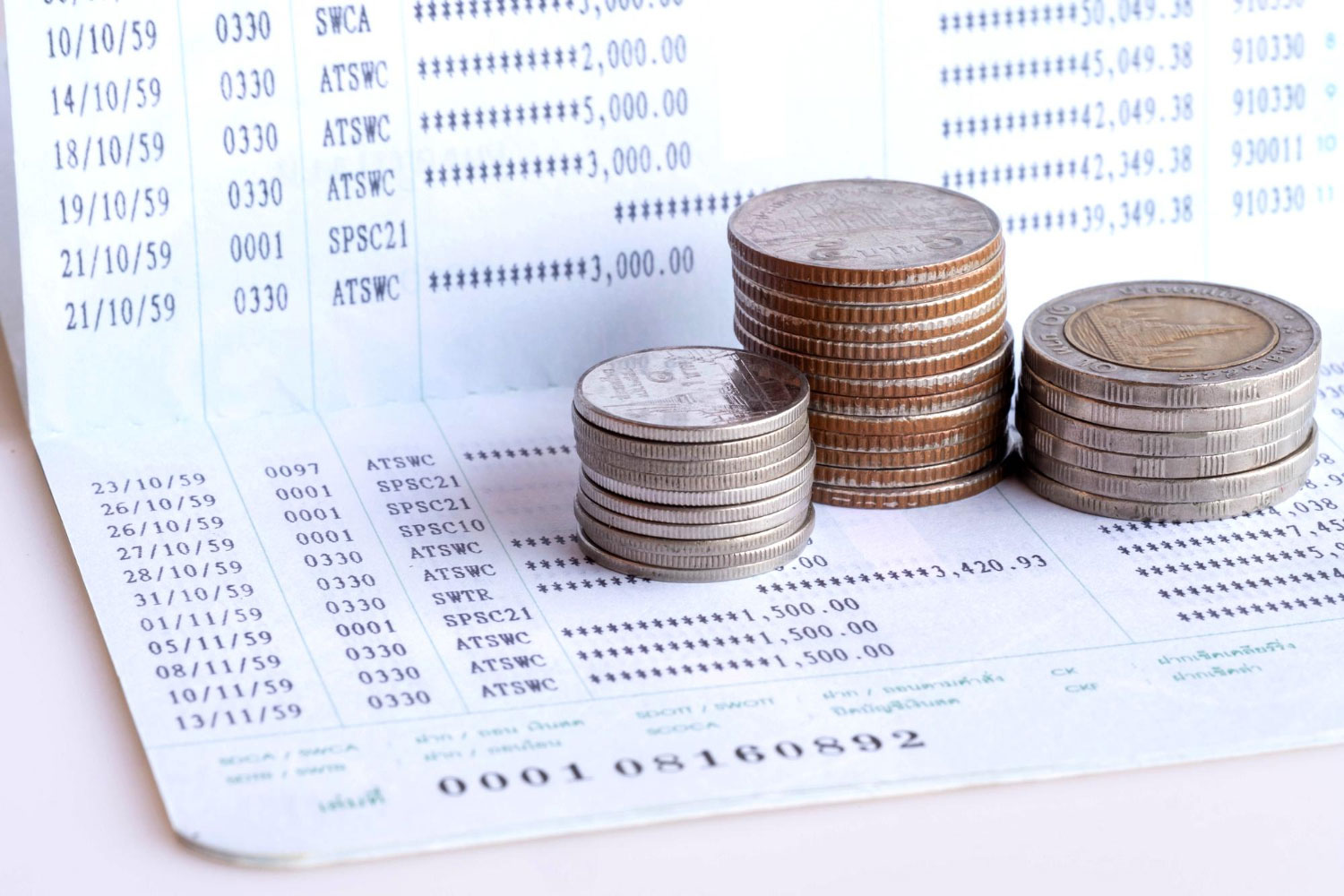 Extrato bancário sobre uma mesa com moedas por cima, representando tradução juramentada de extrato bancário.
