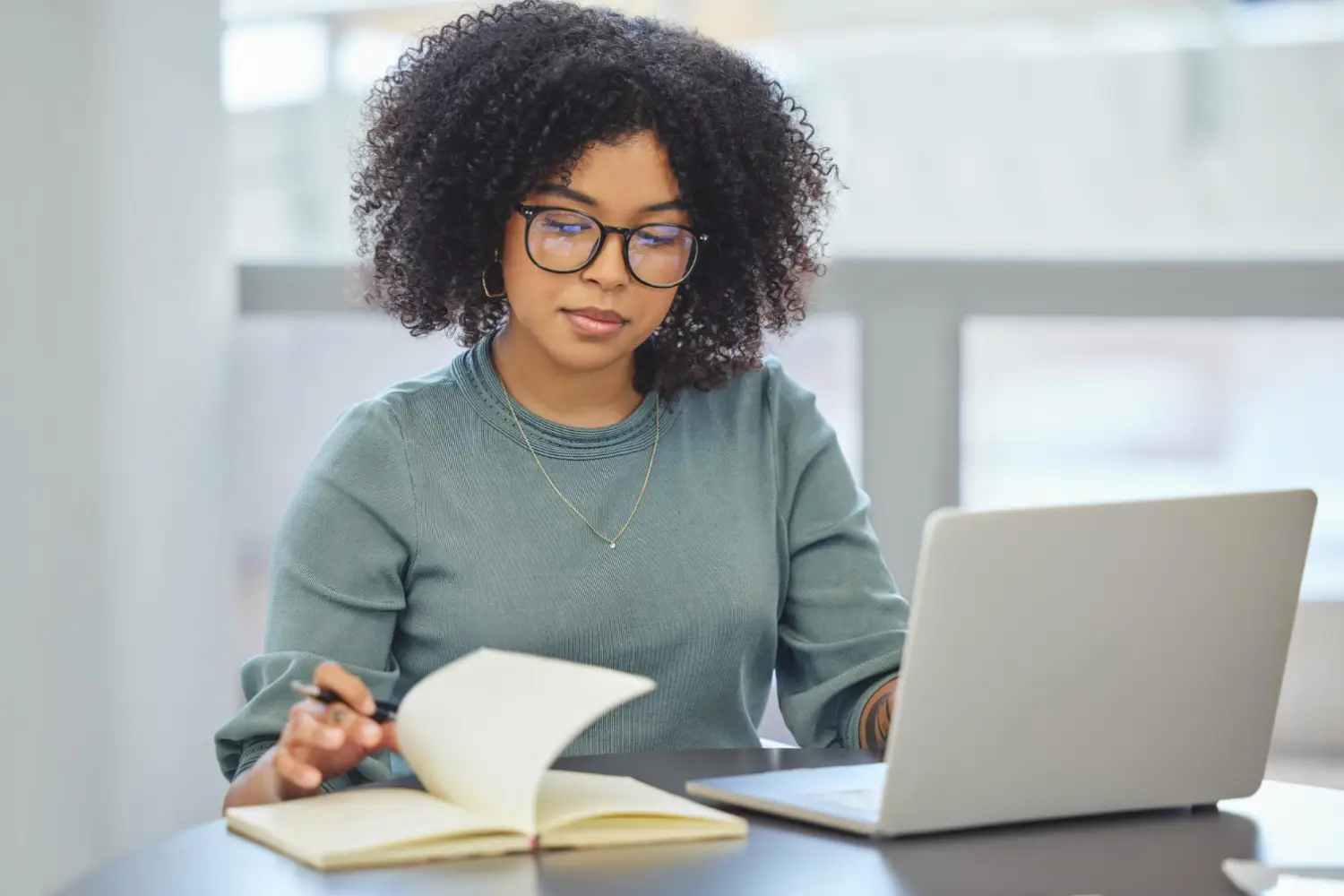 Acadêmica terminando seu trabalho no notebook e pesquisando serviços de tradução de artigos científicos.