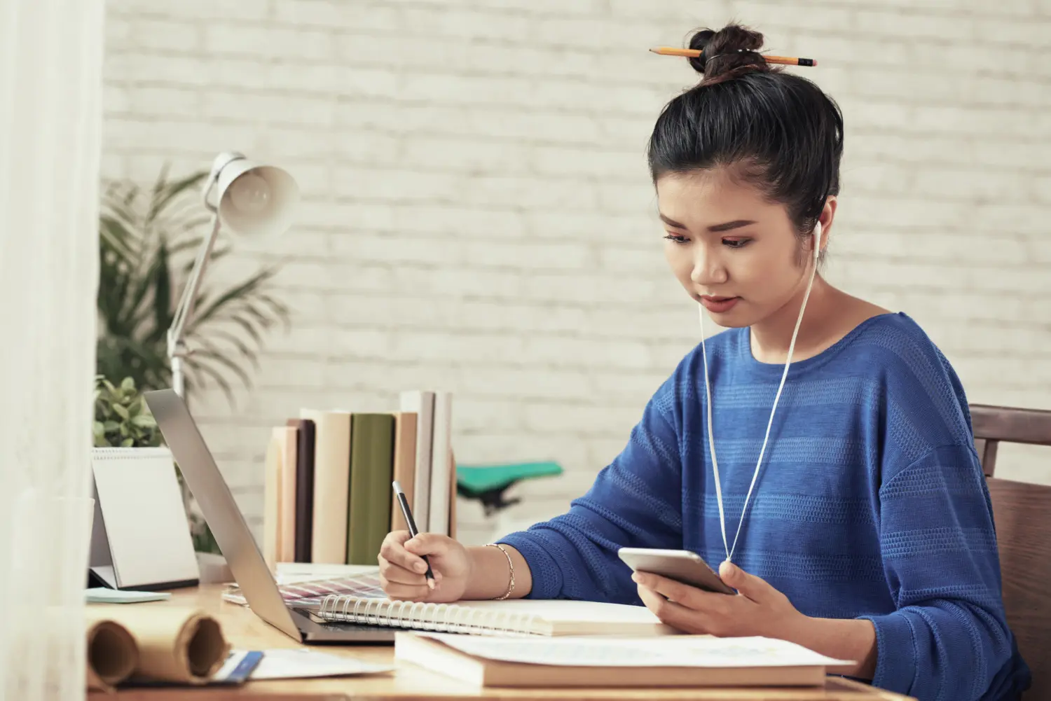 Mulher concentrada de fones enquanto estuda mandarim