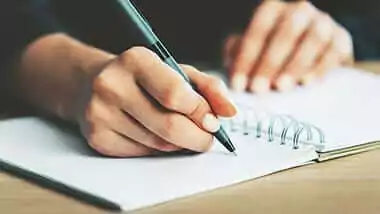 jovem escrevendo em caderno os documentos necessários para realizar uma tradução juramentada na empresa de tradução