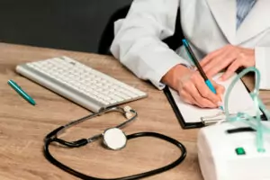 Receita médica sobre uma mesa com instrumentos médicos e teclado de computador, representando tradução de receita médica